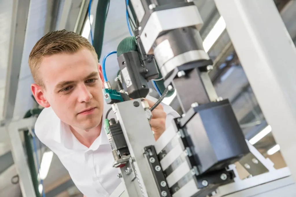 Auszubildender richtet eine mechanische Baugruppe aus
